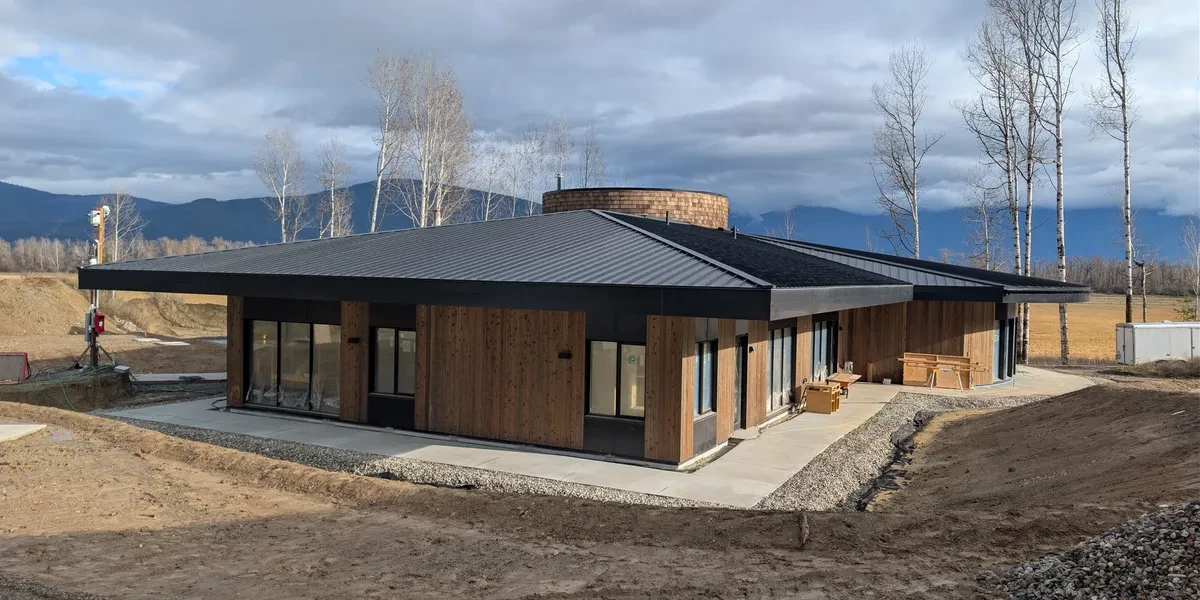 Modern wood and metal clad home with dark standing seam roof mountain valley