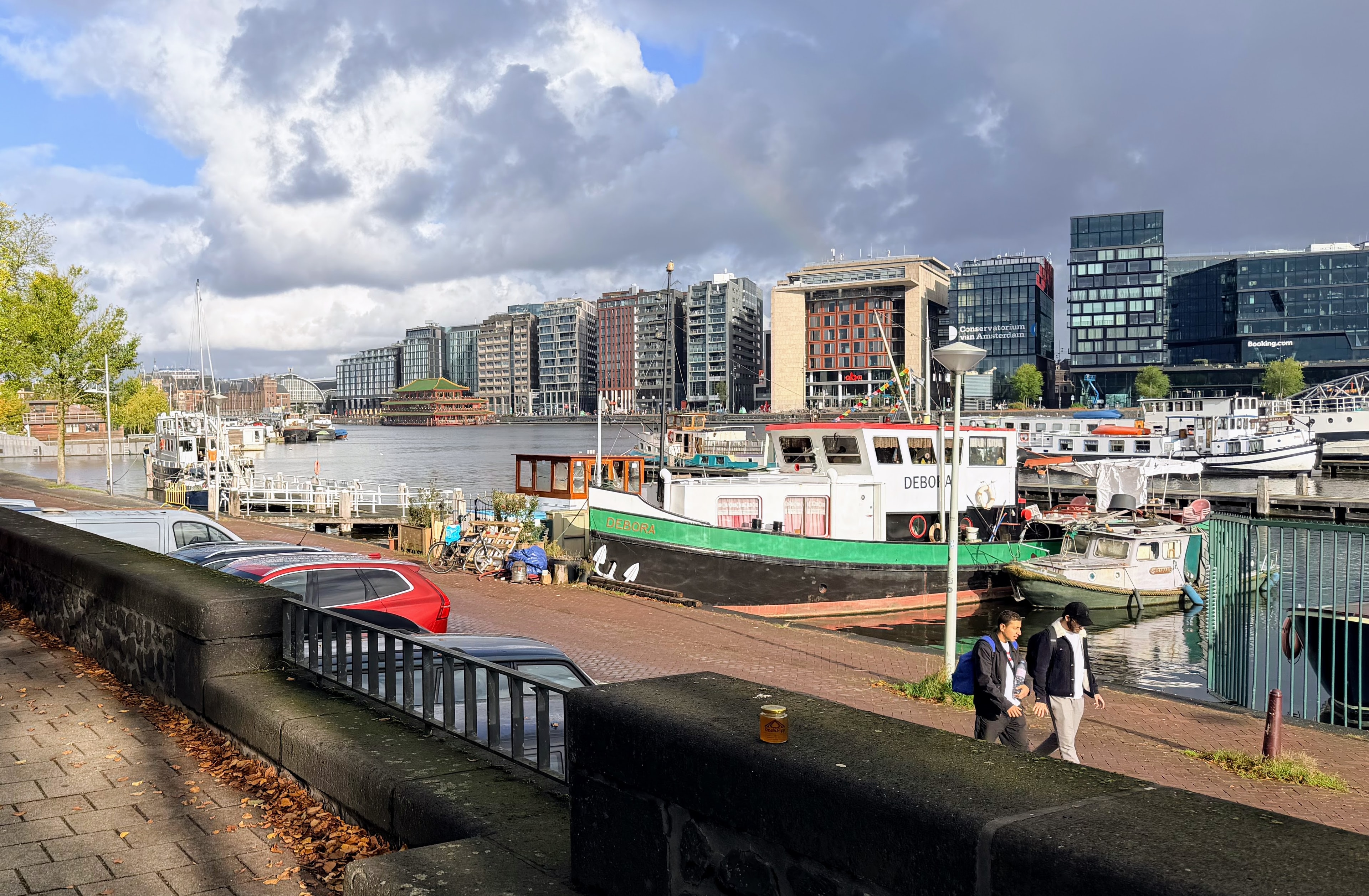 OneKEpp honey jar on a harbour wall with Amsterdam houseboats and the city skyline behind
