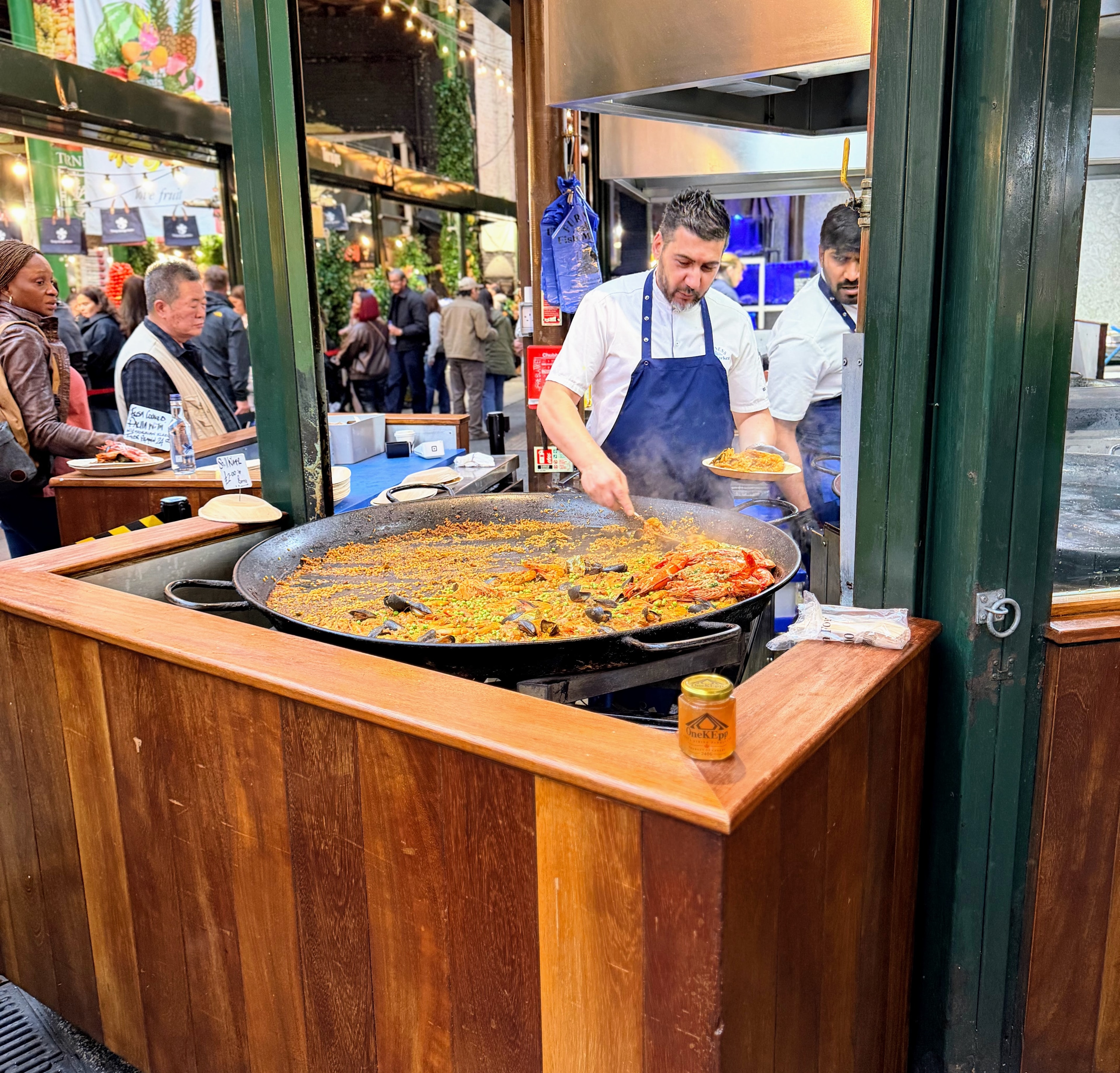 OneKEpp honey jar beside a giant paella pan at Borough Market London
