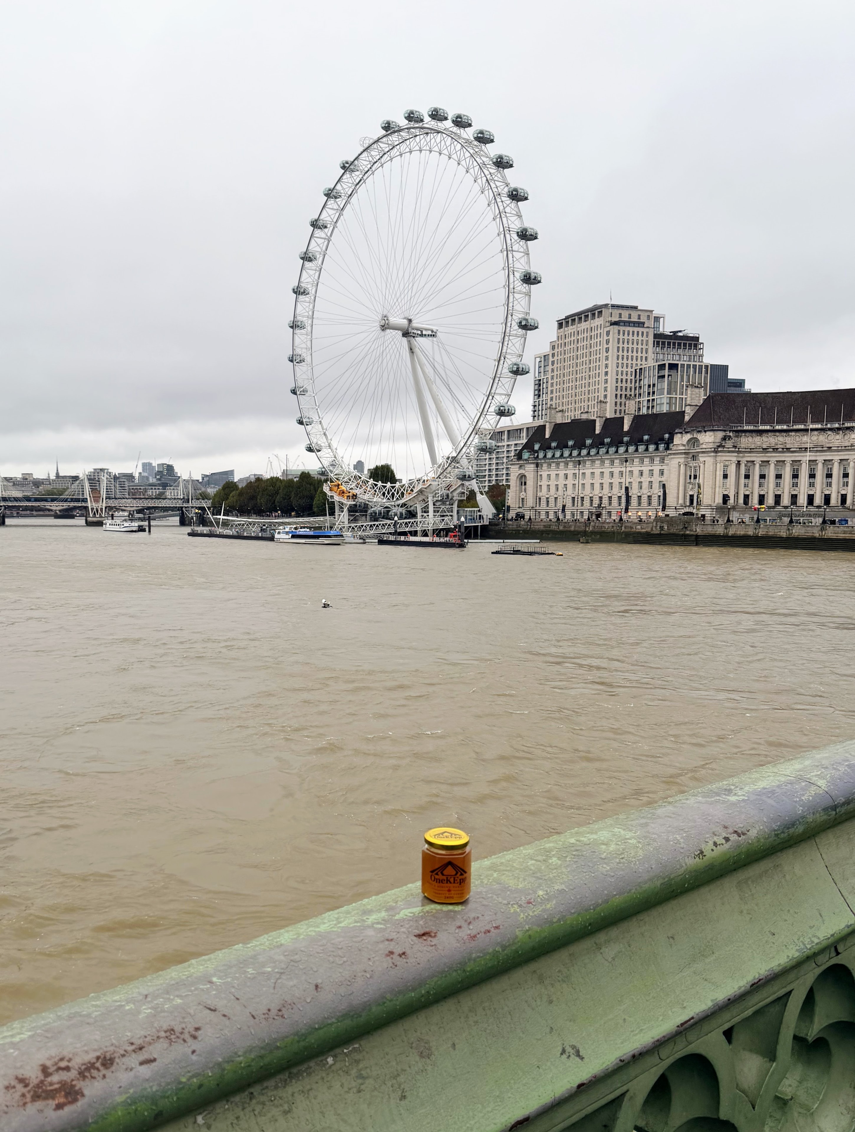 OneKEpp honey jar on Westminster Bridge railing with the London Eye across the Thames