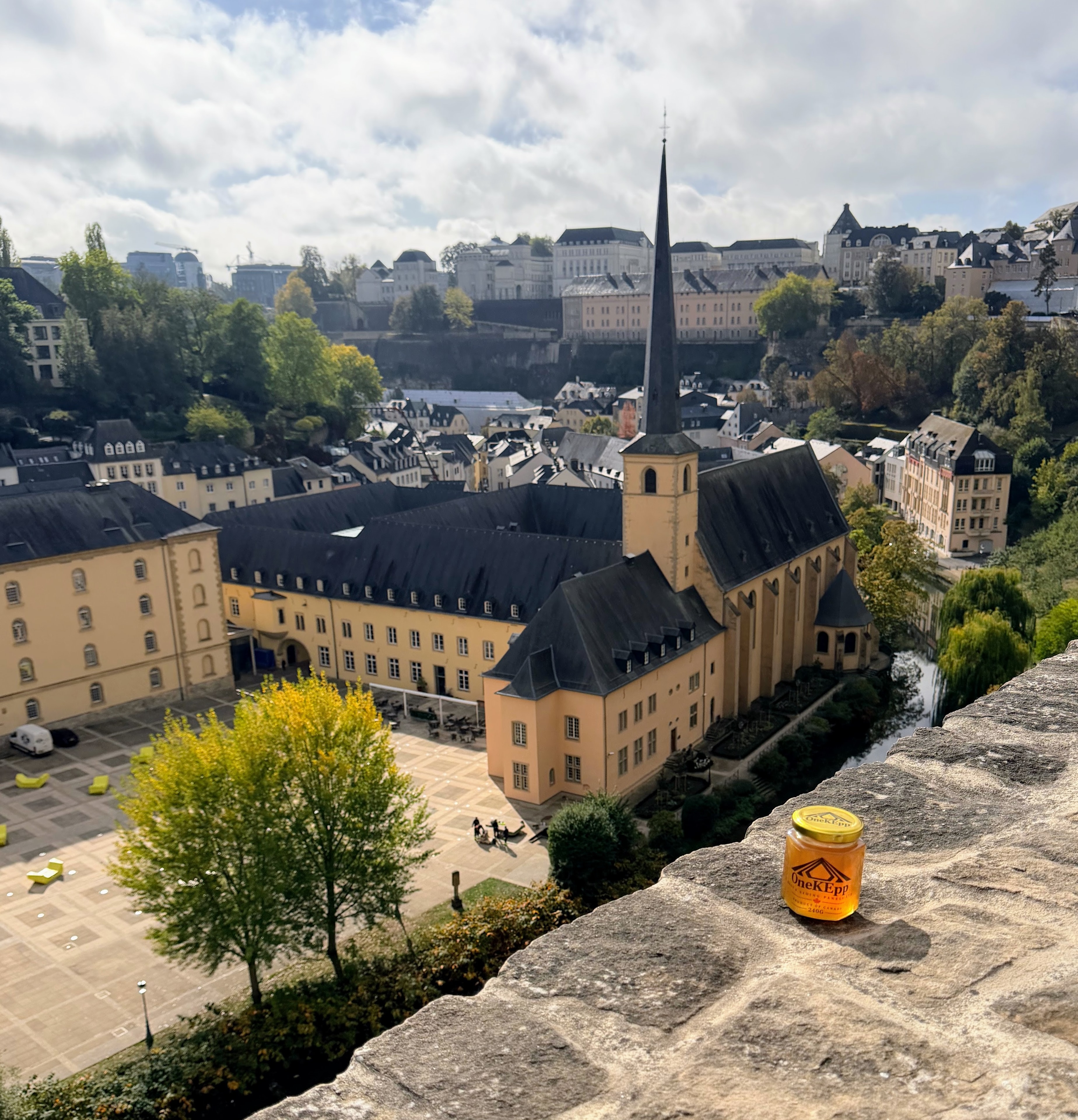OneKEpp honey jar on a stone ledge overlooking the Neumünster Abbey and Luxembourg City's Grund quarter